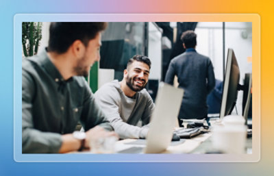Two people looking at a laptop screen and laughing together.