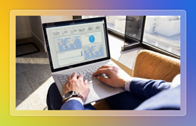 A hand with a watch typing on a laptop keyboard.