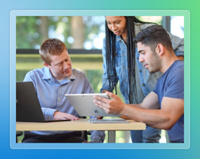 Three employees discussiing something while looking at a tablet.