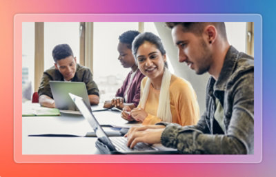 Group of colleagues working together at a table with laptops during a collaborative session.