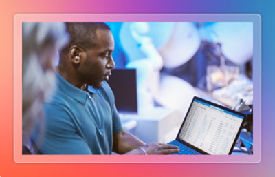 Man talking to another person looking at laptop screen