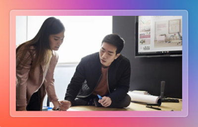 A man and woman looking at a pen.