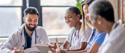 Healthcare professionals collaborating and reviewing information together in a clinical setting.