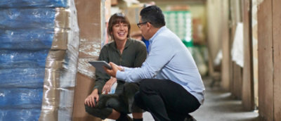 A man and woman looking at a tablet.