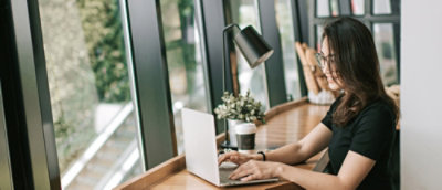 A person sitting at a desk using a laptop.