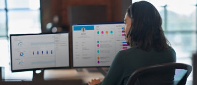 A person wearing a white shirt is looking at a computer screen.