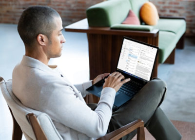 A person sitting in a chair using a laptop.
