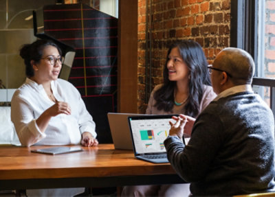 A group of people sitting around a table and discussing.