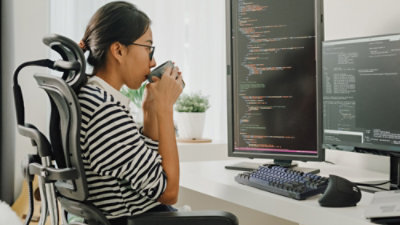 Woman sitting at here work desk and drinking