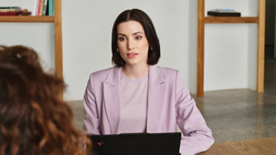 Person seated at a desk using a laptop in an office setting.