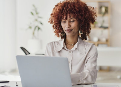 A woman is looking at the laptop.