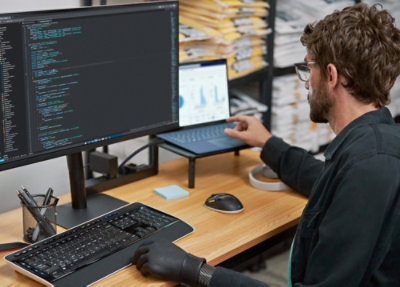 A person sitting at a desk using a laptop.