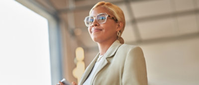 A woman wearing glasses and a suit.