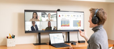 A woman wearing headphones and using a computer.