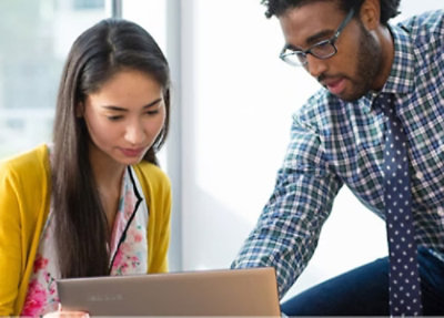 Two professionals looking at a laptop