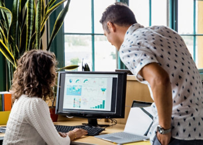 Two employees looking at a computer screen.