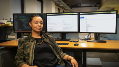 Working at a desk with multiple computer monitors.