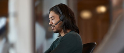 Person seated indoors, listening attentively during a meeting or conversation.