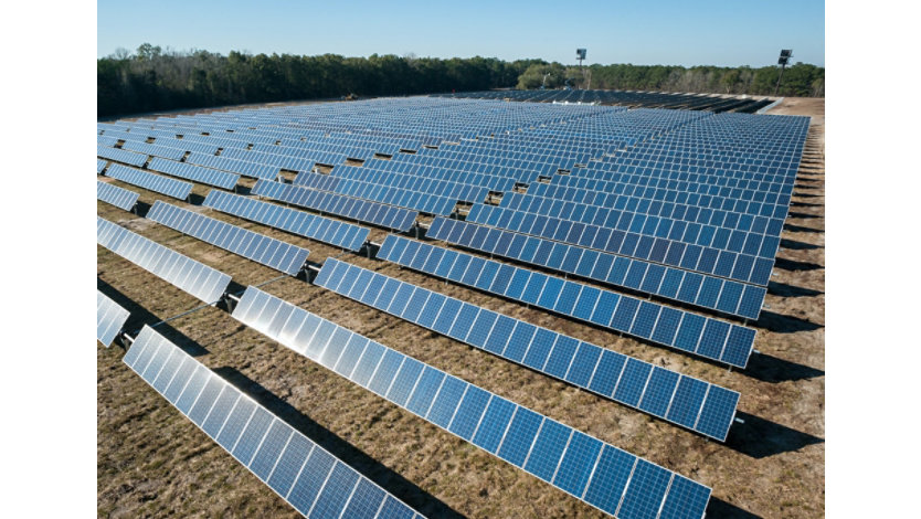 Field with rows of solar panels.