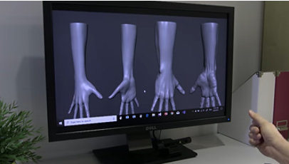 Images of hands in different positions shown on a monitor.