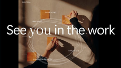 A hand writing on a wall with the text See you in the work visible.