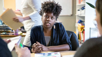 Nainen uppoutuneena keskusteluun toimistossa