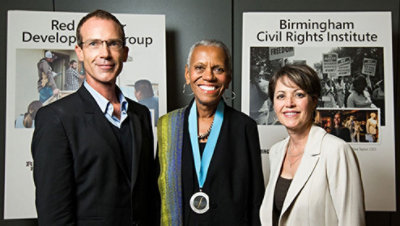 Mies ja kaksi naista seisomassa vierekkäin.