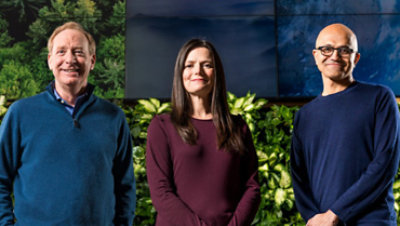 Brad Smith, Amy Hood ja Satya Nadella hymyilemässä toimiston pihalla