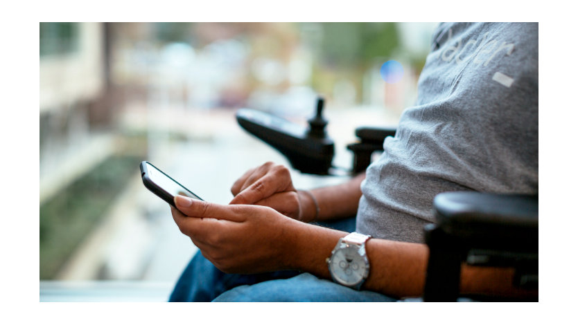  A man who uses a wheelchair browses on a smartphone.