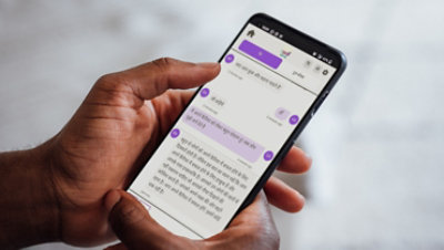 Hands holding a phone showing screen of interaction between user and Iwill GITA in Hindi for mental health 