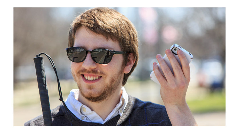 Un homme aveugle tenant son téléphone.