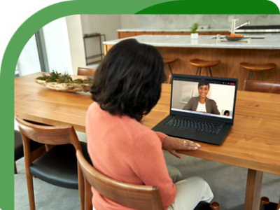 A woman sitting at a table with a laptop in front of her.
