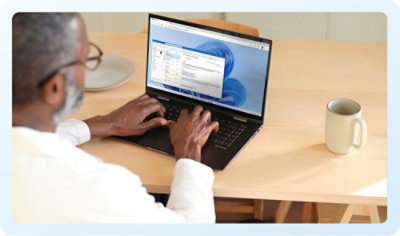 A person typing on a laptop with text visible on the screen.