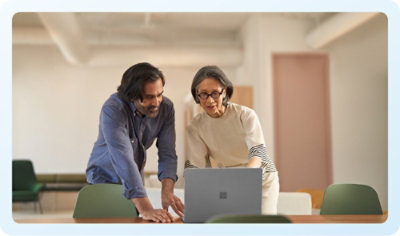 two persons looking at laptop