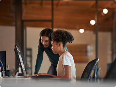 Một người và một người khác đang nhìn vào máy tính