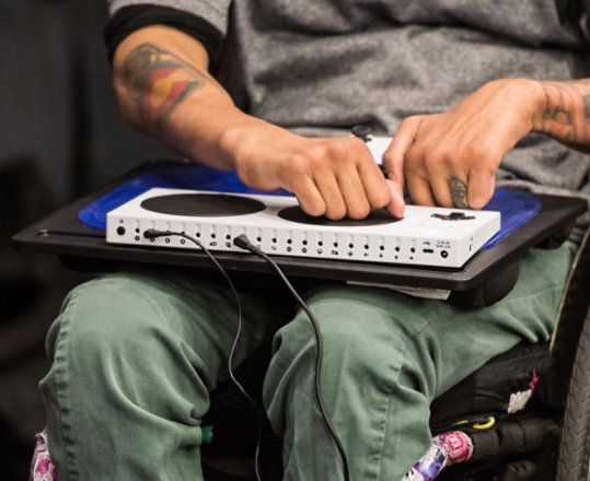 A person in a wheelchair uses the Xbox Adaptive Controller.