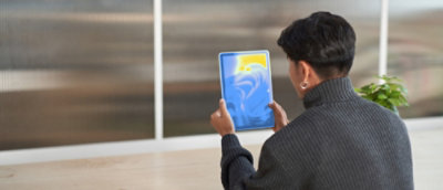Person holding a tablet with a colorful abstract display.