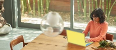 A woman wearing glasses works on a laptop