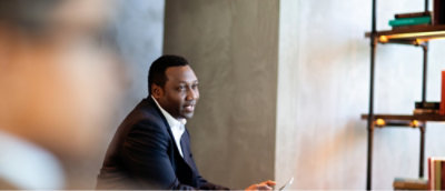 Un hombre con un traje sentado en una mesa.