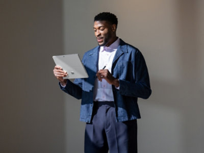 Person standing and reviewing a tablet in a studio setting.