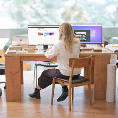 A girl sitting at a desk working on a computer.