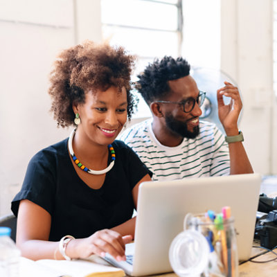 Dos personas sentadas mirando un equipo