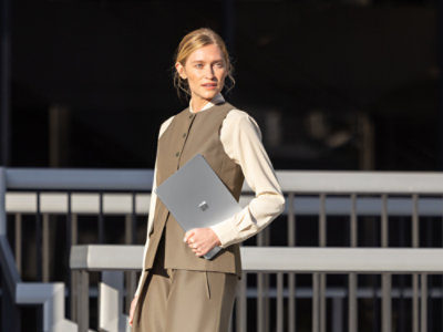 ある人物が、5G対応の「Surface Commercial Laptop」を手に持ちながら道路を横断している様子は、公共の場でもこのデバイスが安全に利用できることを示唆している。