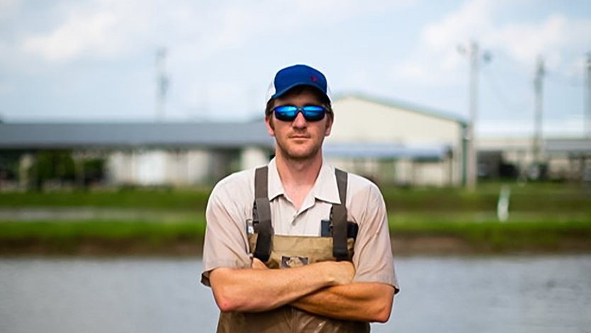 A person in coveralls in front of a building