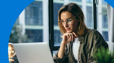 Osoba sedi i gleda laptop računar.