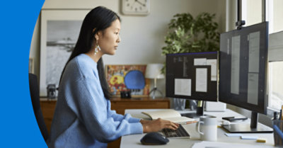 Una persona sentada frente a su escritorio utilizando varios monitores