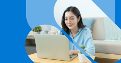 Людина сидить на підлозі й використовує ноутбук, розташований на журнальному столику