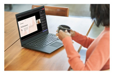 A person sitting at a table with a cup of coffee participating in a Teams meeting on a laptop where a presentation is being given.