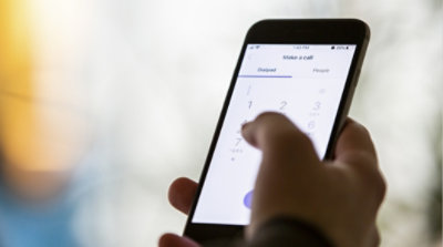 A hand making a phone call through Teams on a mobile phone