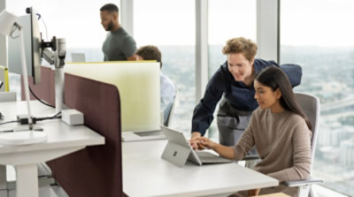 People working together in groups of two in cubicles in an office